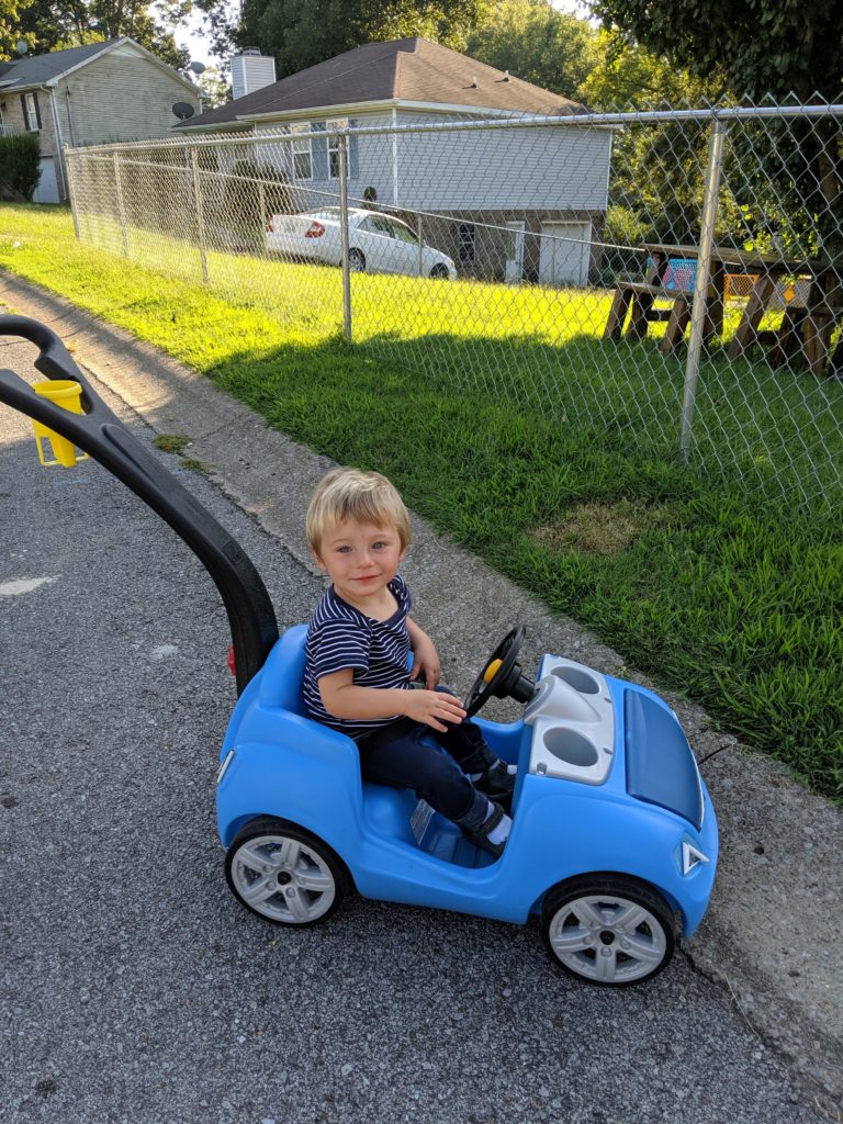 toddler sitting in blue Step2 Whisper Ride ride-on push car