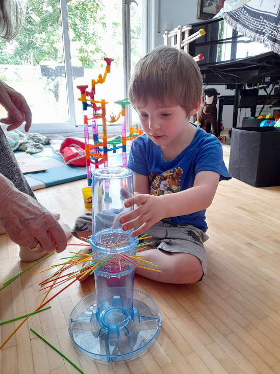 concentrated toddler and grandma playing Kerplunk