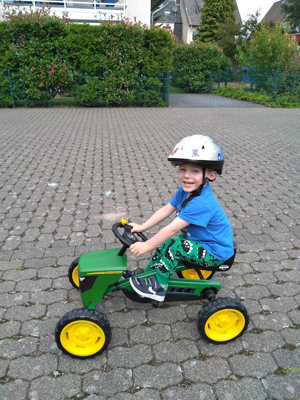 happy toddler riding on John Deere tractor go-kart