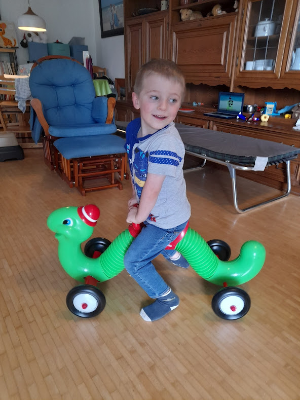 toddler riding on Radio Flyer Inchworm ride-on toy